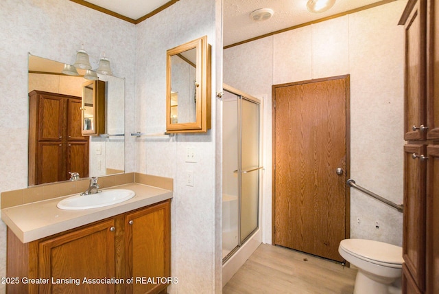 bathroom with crown molding, a textured ceiling, vanity, a shower with door, and hardwood / wood-style floors