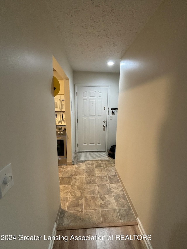 hall featuring a textured ceiling