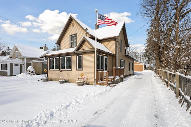 snow covered property featuring a storage shed