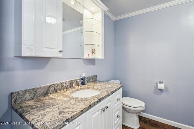 bathroom featuring wood-type flooring, toilet, vanity, and ornamental molding