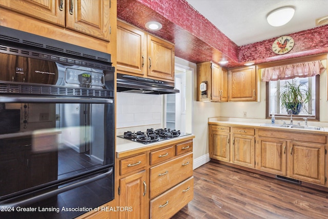 kitchen featuring black oven, dark hardwood / wood-style flooring, decorative backsplash, sink, and gas cooktop