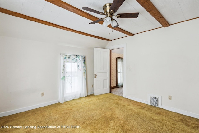 carpeted empty room with ceiling fan and lofted ceiling with beams