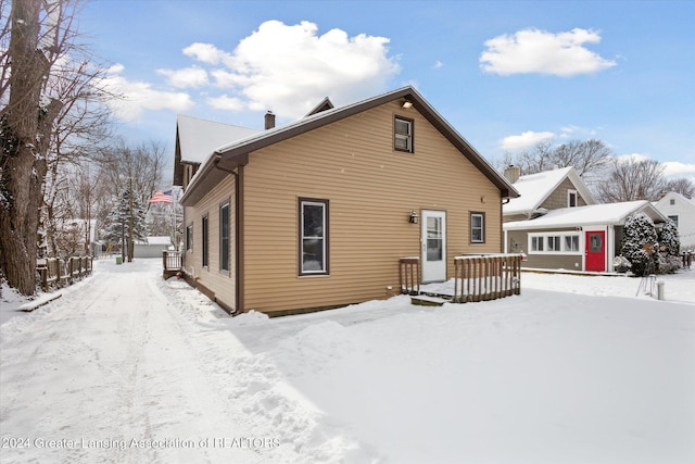 view of snow covered rear of property