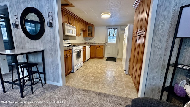 kitchen featuring white appliances, light colored carpet, and sink