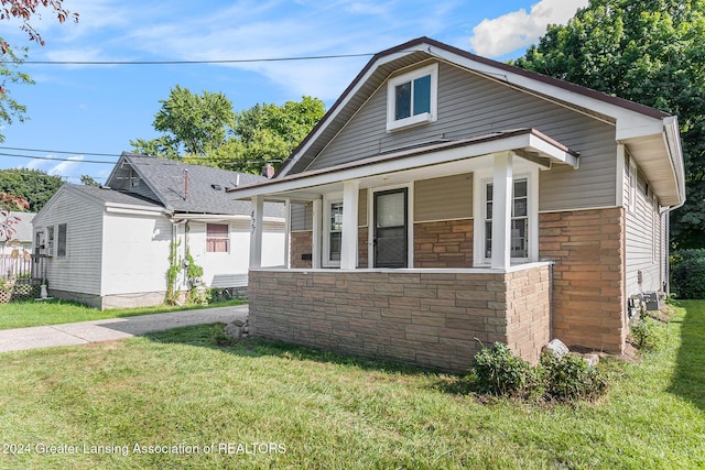 bungalow-style house featuring a front lawn and covered porch