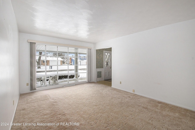 carpeted spare room with visible vents and baseboards