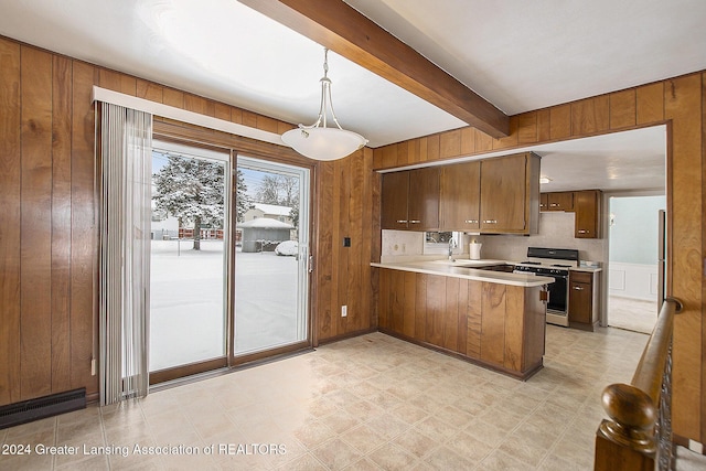 kitchen with brown cabinetry, decorative light fixtures, a peninsula, white gas range, and light countertops