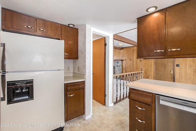 kitchen with white fridge with ice dispenser, light countertops, dishwasher, and light floors