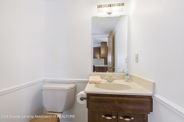 half bath featuring toilet and vanity