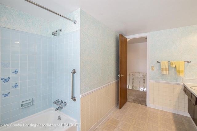 bathroom featuring wallpapered walls, shower / bathtub combination, and wainscoting