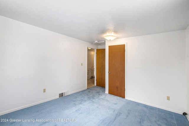 unfurnished room featuring carpet flooring, visible vents, and baseboards