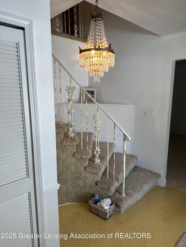 stairs featuring speckled floor and an inviting chandelier