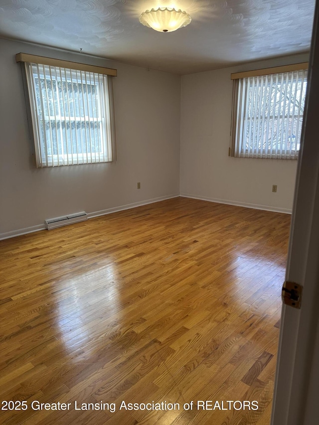 unfurnished room with baseboards and wood finished floors