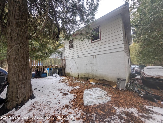 snow covered property with a wooden deck