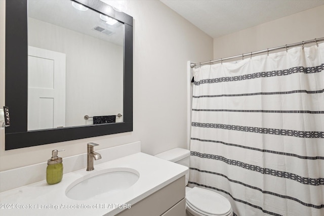 bathroom featuring vanity, a textured ceiling, and toilet