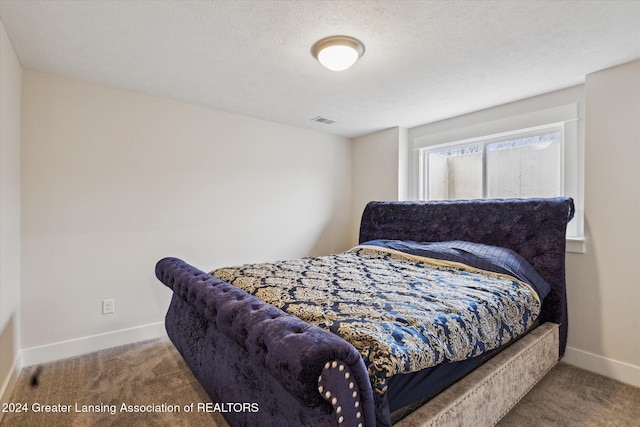 bedroom featuring carpet floors and a textured ceiling