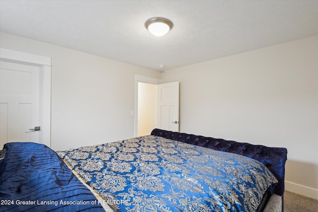 bedroom featuring carpet floors and a textured ceiling