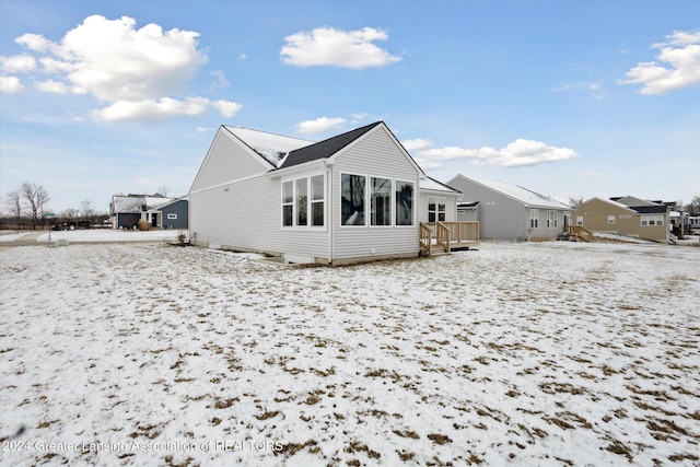 snow covered rear of property featuring a wooden deck