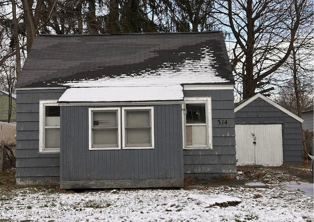 snow covered property featuring a storage shed