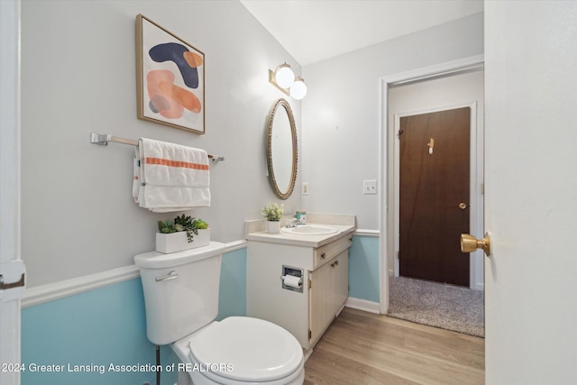 bathroom featuring toilet, hardwood / wood-style floors, and vanity