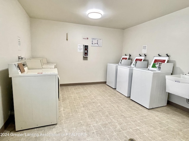 washroom with sink, independent washer and dryer, and electric panel