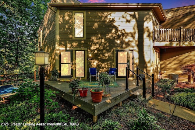 back of property with a balcony, central AC, and a deck