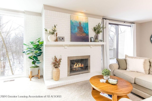 carpeted living room with a brick fireplace