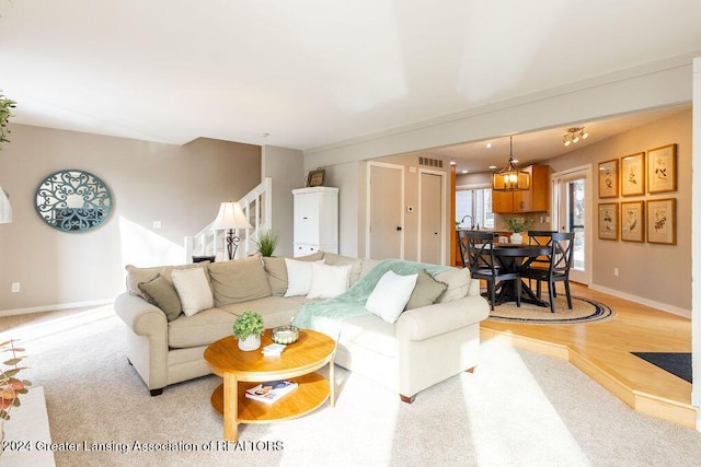 living room featuring light colored carpet and a chandelier