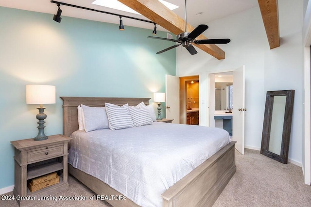 carpeted bedroom with ensuite bath, track lighting, beam ceiling, and ceiling fan