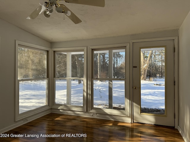 doorway to outside with ceiling fan, vaulted ceiling, dark wood-type flooring, and a textured ceiling