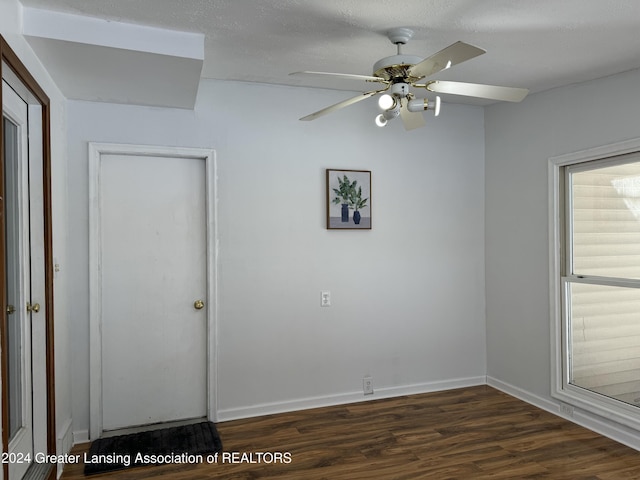 unfurnished room featuring dark wood-type flooring, ceiling fan, and a textured ceiling