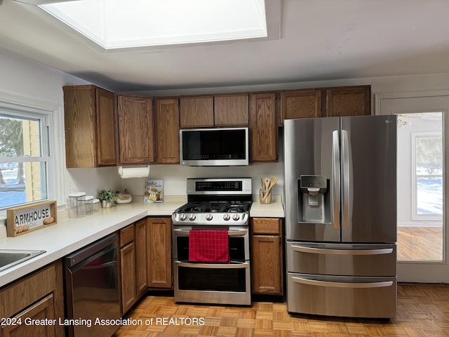 kitchen with appliances with stainless steel finishes and light parquet floors