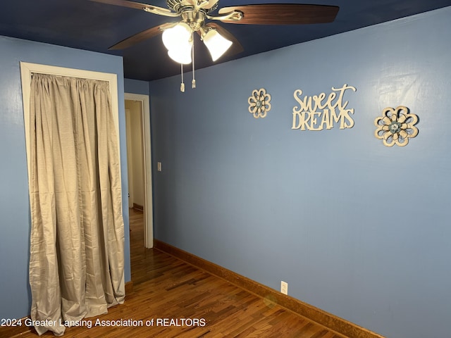 interior space with ceiling fan, a closet, and hardwood / wood-style flooring