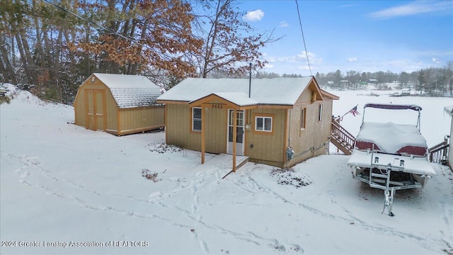 snow covered property featuring a shed