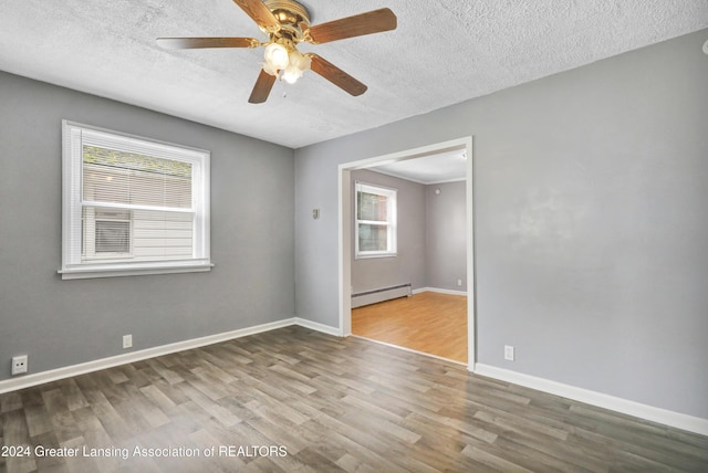 unfurnished room featuring ceiling fan, baseboard heating, a textured ceiling, and hardwood / wood-style flooring