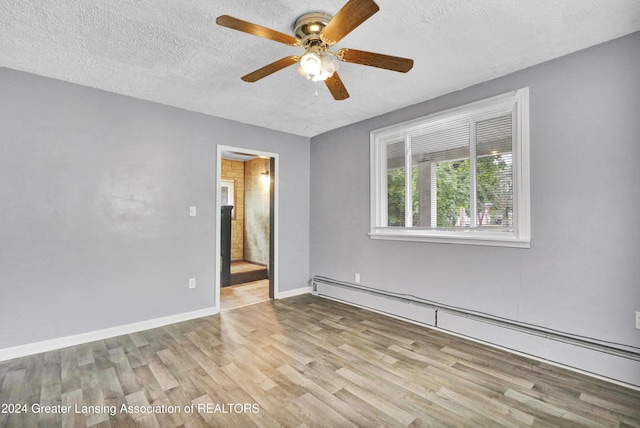 unfurnished room with a baseboard heating unit, a textured ceiling, ceiling fan, and light hardwood / wood-style floors