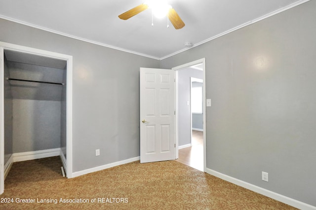 unfurnished bedroom with ceiling fan, crown molding, and light carpet