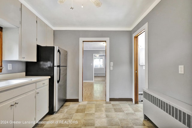 kitchen featuring baseboard heating, white cabinetry, radiator heating unit, and crown molding