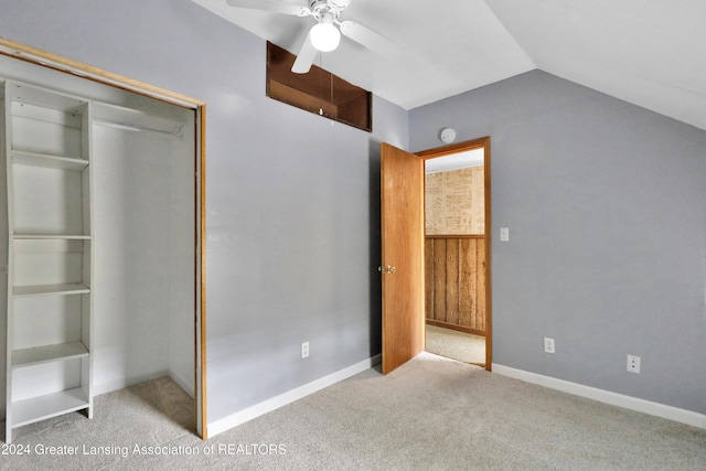 unfurnished bedroom with a closet, lofted ceiling, light carpet, and ceiling fan