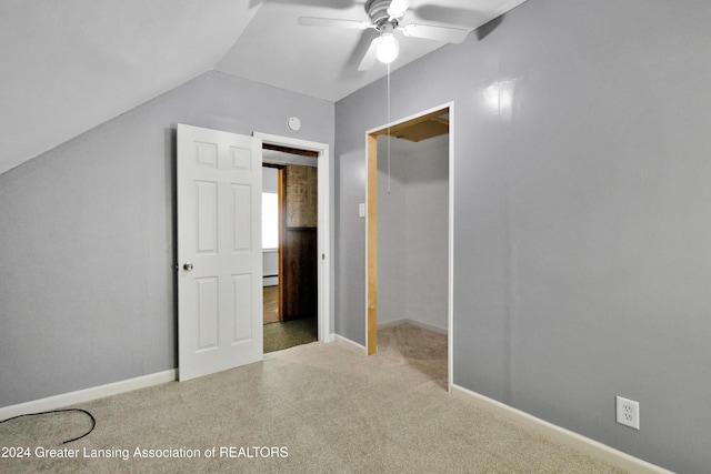 unfurnished bedroom featuring ceiling fan, light colored carpet, a closet, and vaulted ceiling