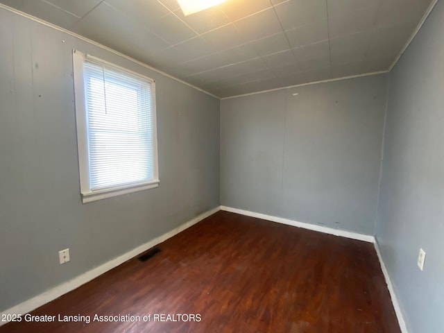 unfurnished room with ornamental molding and dark hardwood / wood-style flooring