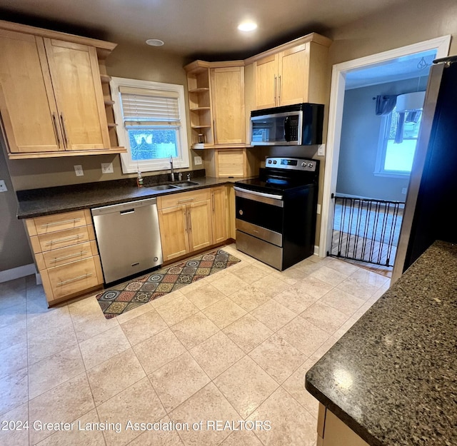 kitchen featuring stainless steel appliances, light tile patterned floors, sink, and light brown cabinetry