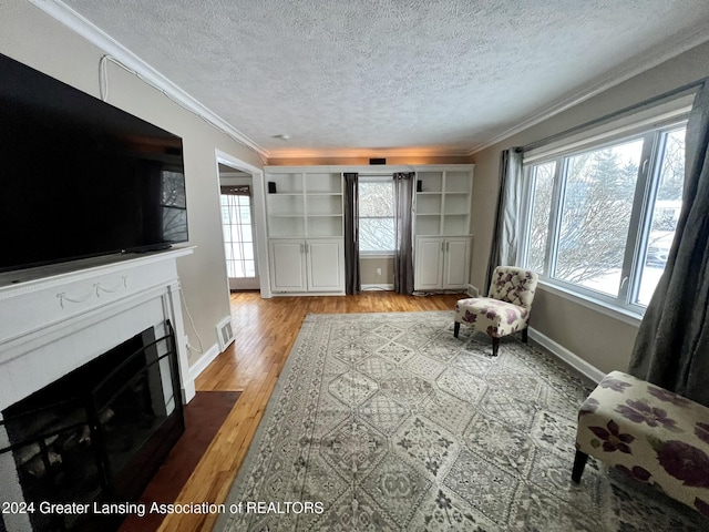 sitting room featuring a wealth of natural light, light hardwood / wood-style floors, and crown molding