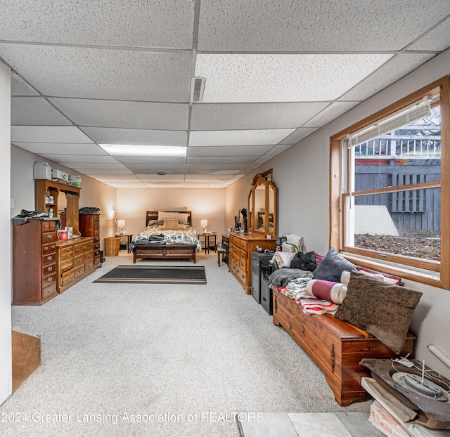 bedroom with light colored carpet and a drop ceiling