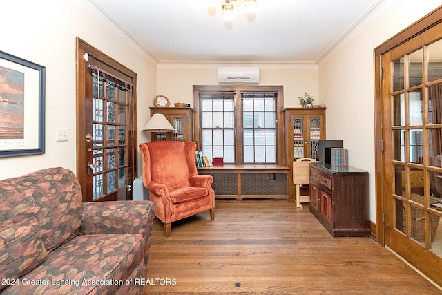 sitting room featuring light hardwood / wood-style floors, french doors, crown molding, and an AC wall unit