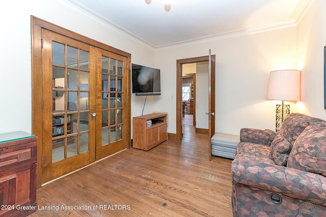 living room with french doors, hardwood / wood-style floors, and crown molding