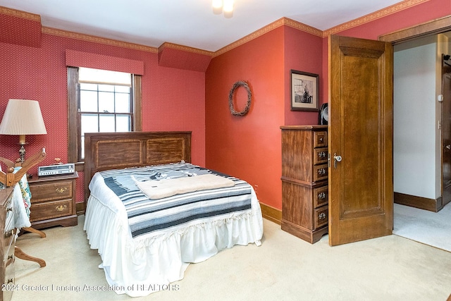 bedroom with crown molding and carpet