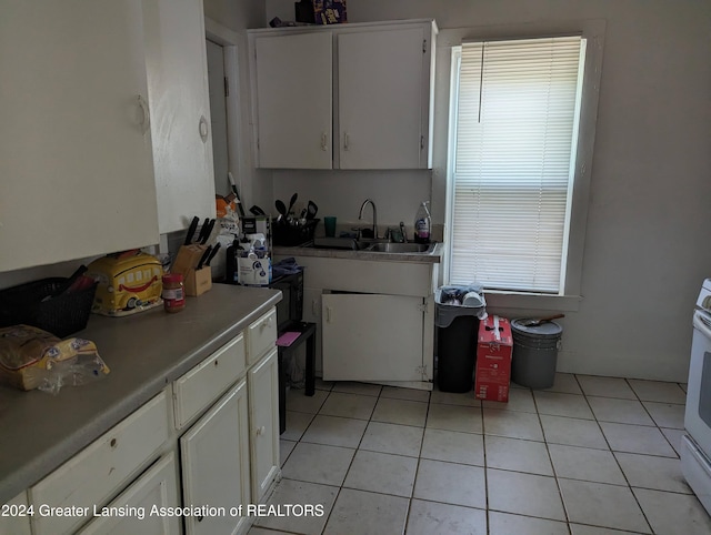 kitchen featuring white cabinets, sink, and light tile patterned flooring