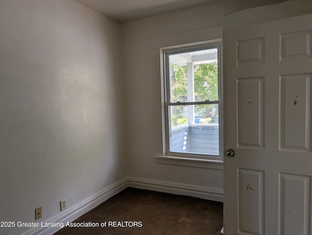 interior space featuring dark colored carpet and baseboards