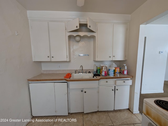 kitchen featuring light tile patterned floors, sink, white cabinets, and white electric range oven